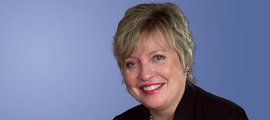 Maryjane Wurth smiling with blue background