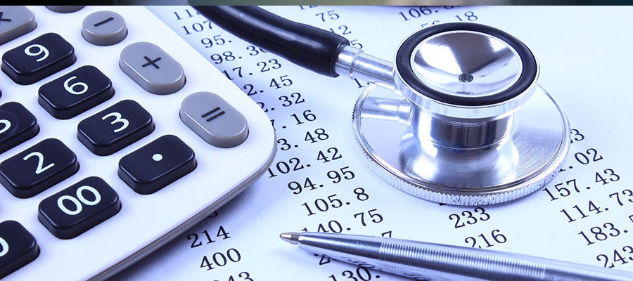 calculator and stethoscope on desk