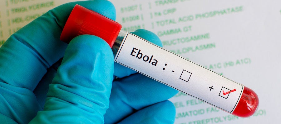 Gloved hand holding red vial that says "Ebola"