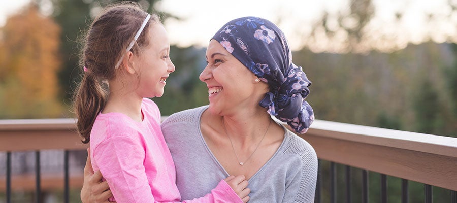 Image of woman with head wrap smiling at daughter 