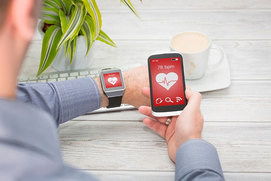 Workforce Innovation patient checking his heart monitor on his watch and mobile phone