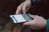 Testing a ‘Fire Alarm’ App for Imminent Behavioral Health Crises. A person types on a phone while using an app for behavioral health.