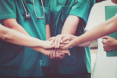 stock photo of medical team huddle with hands stacked