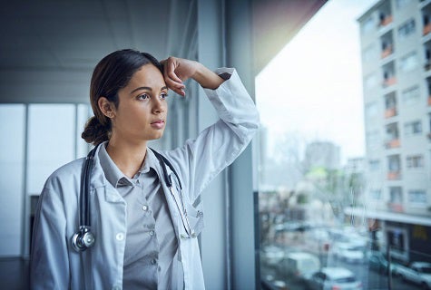 stock photo of health worker on hospital floor with head in hands