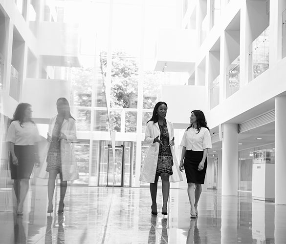 BW view with reflection of two people walking in office building hallway