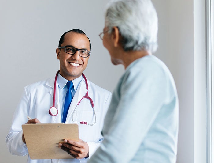 Age-friendly doctor smiling at older female patient