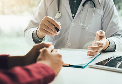 doctor sitting at desk talks to patient