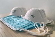 Providers Stockpile, Leverage Tech to Address Potential Supply Shortages. A stack of blue surgical masks with N95 masks on top of them.