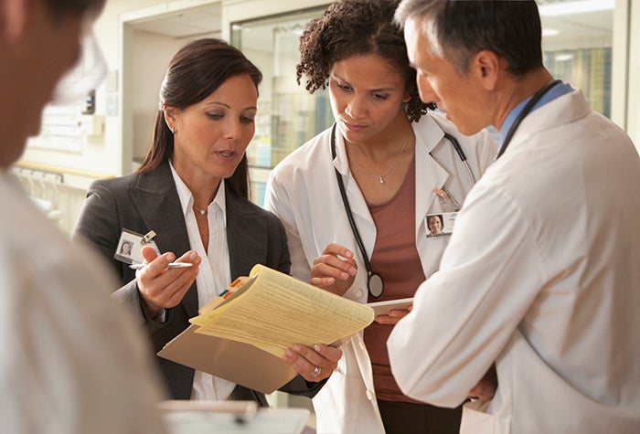 hospital staff looking at a legal pad in the hallway