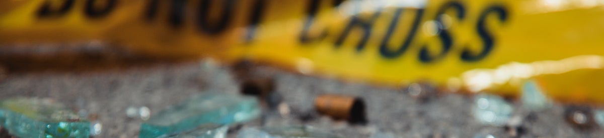 police tape bullet casings and broken glass