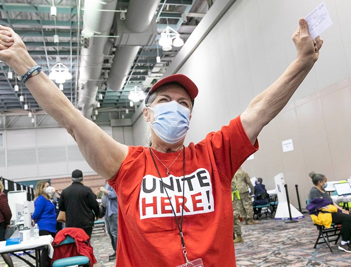 Person at AtlantiCare vaccination event stands with arms raised in celebration