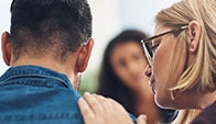 woman comforts man in group therapy session