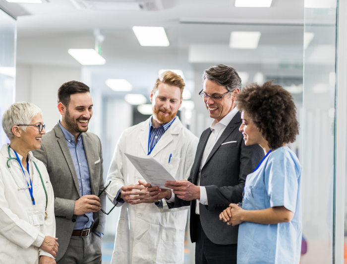 Happy doctors and businessmen reading a medical document