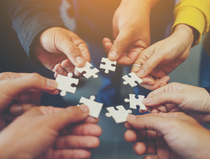 Puzzle pieces in hands forming a circle