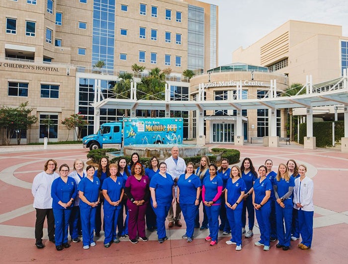 Wolfson staff stand in front of a fountain outside Baptist Medical Center and Wolfson Children's Hospital