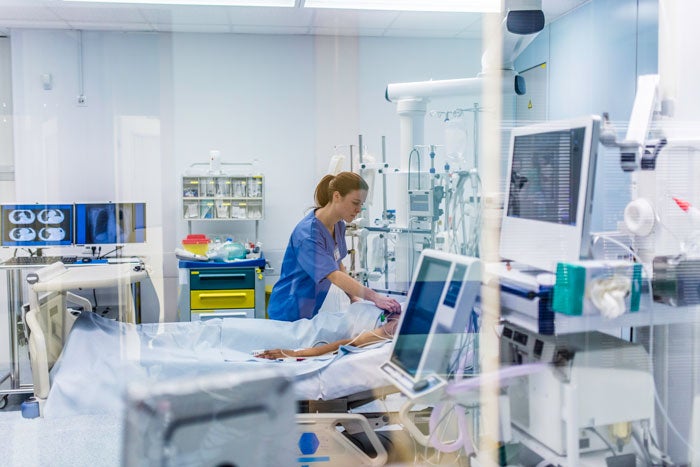 health worker tends to patient in hospital bed