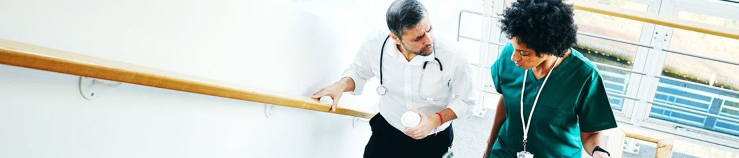 Two medical people walking up a staircase