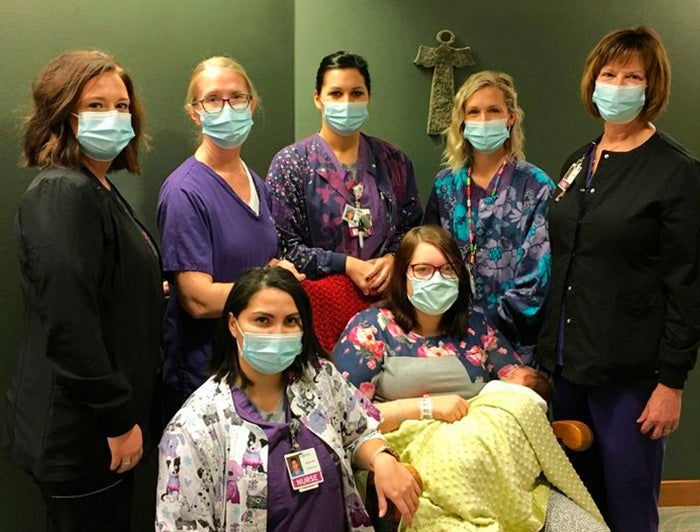 Staff surround a mother and baby