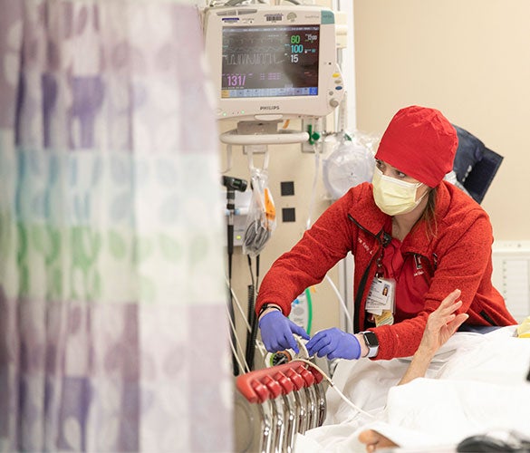 Nurse working on a patient in bed