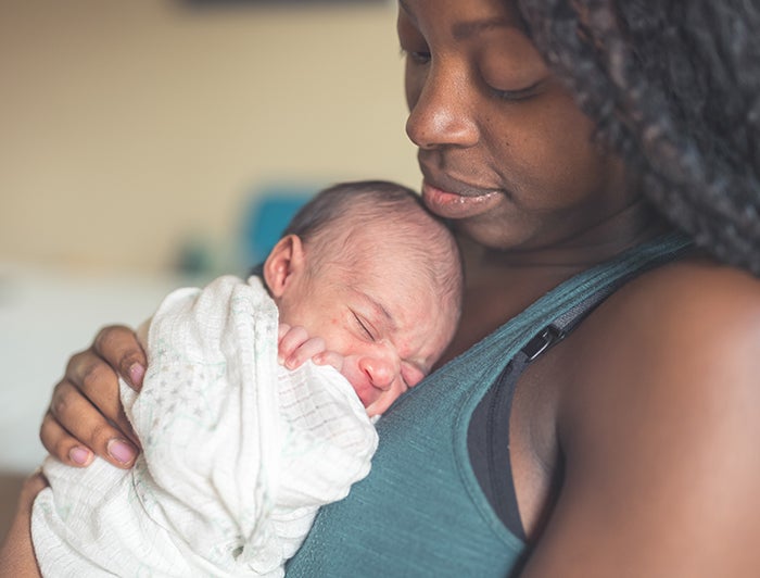 Black mother cradling newborn