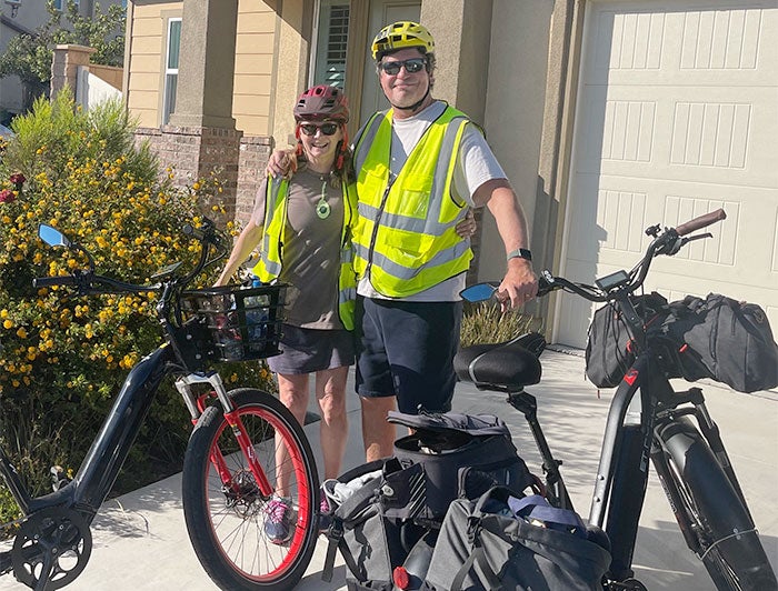 Daniel Eagle and partner, dressed in cycling safety gear, pose with bikes