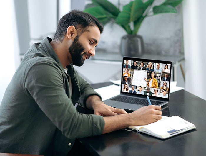 Male on a virtual call and taking notes