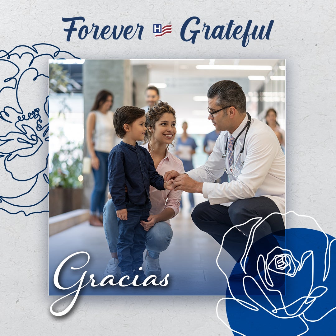 Forever Grateful: Gracias - a male doctor in white coat crouches to talk to a young boy and his mother