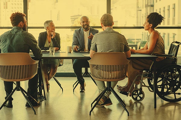 diverse professionals sit at a conference table