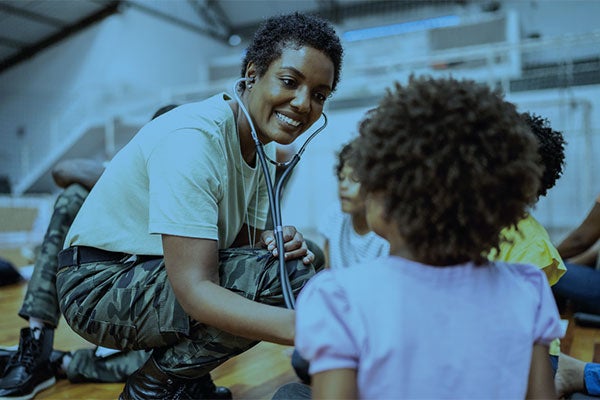 military doctor examining child with stethoscope