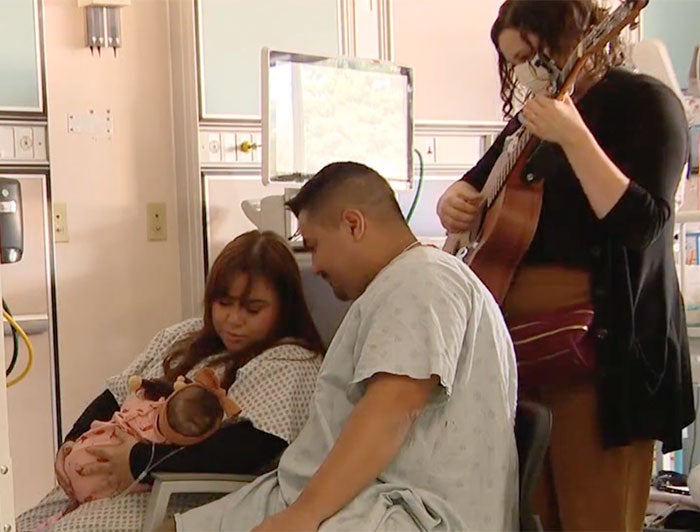 UCSF Benioff music therapist Rebecca Hines plays for the Fernandez family