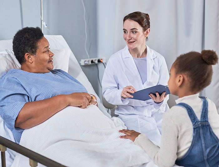 Person in hopital bed with child near