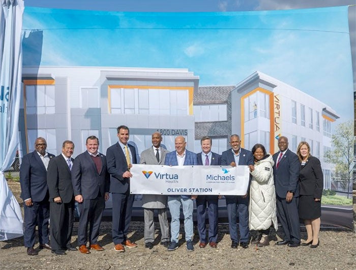 Telling the Hospital Story: Virtua, Michaels leaders at groundbreaking stand ouside in front of a large rendering