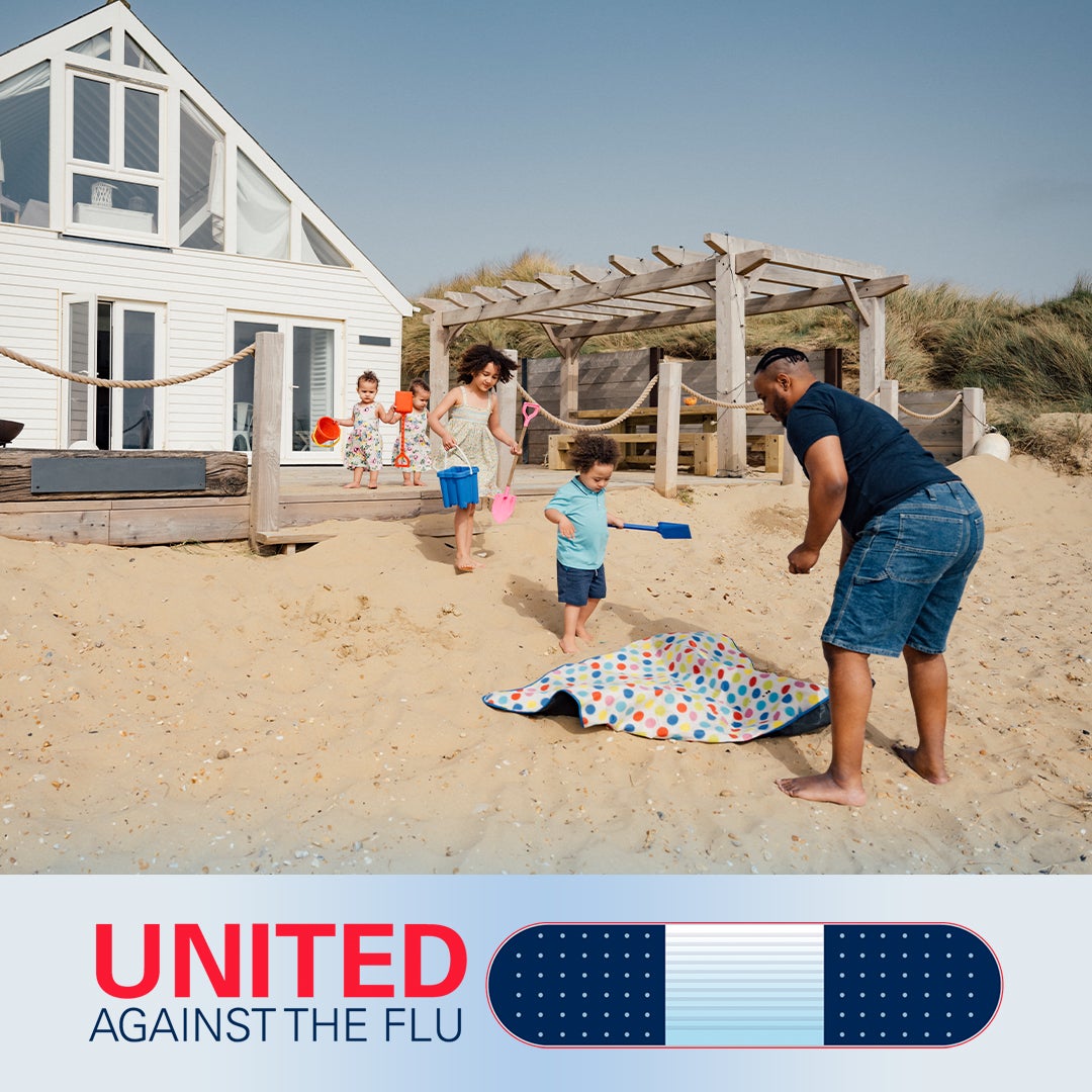 united against the flu logo below image of a father and four young children playing in the sand in front of a beach house and pergola