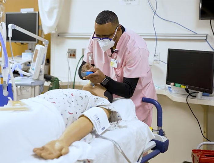 Clinician works on mannequin in simulation