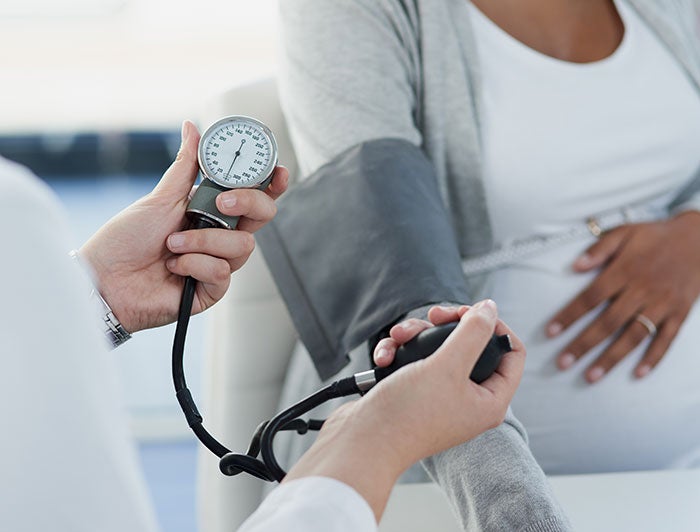 Northern Light. Stock photo of clinician measuring pregnant patient's blood pressure.