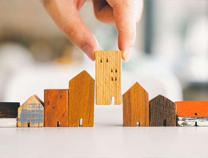 Intermountain Health. Hands line up wooden toy housing blocks