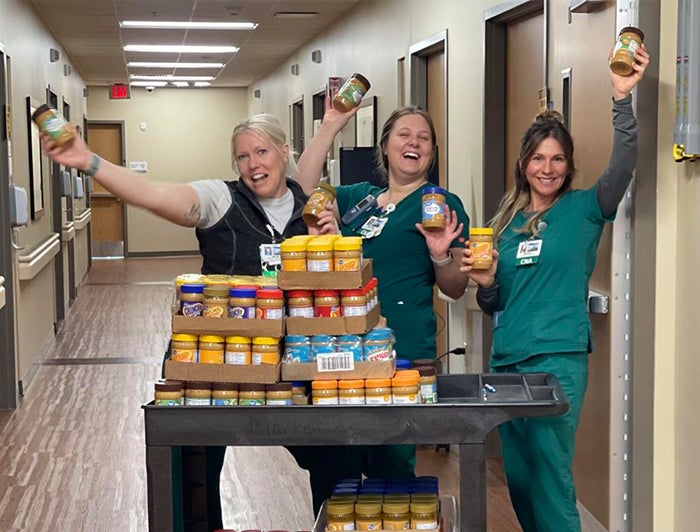Mat-su Regional General Hospital Staff pose with cases of peanut butter