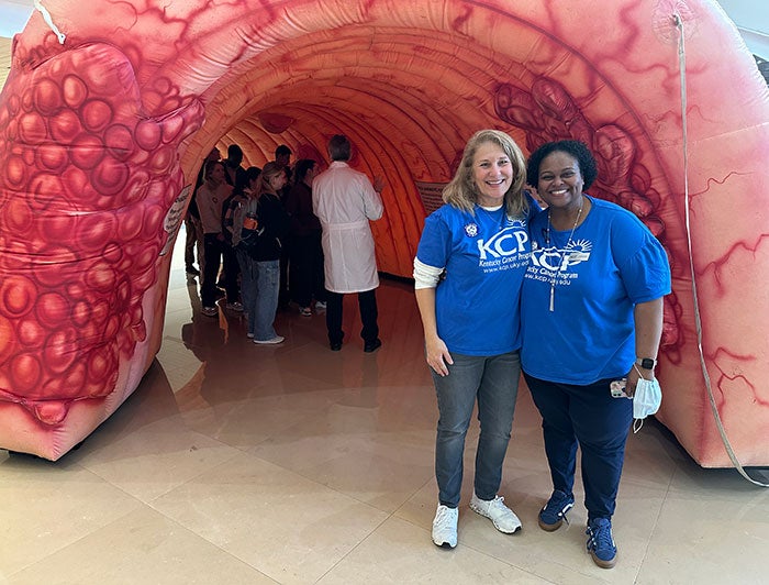 University of Kentucky Albert B. Chandler Hospital. Two women in CHP shirts stand at the entrance to the colon