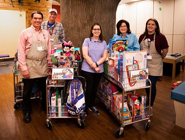 Hospital staff and volunteers stand with Jarrett's Joy Carts
