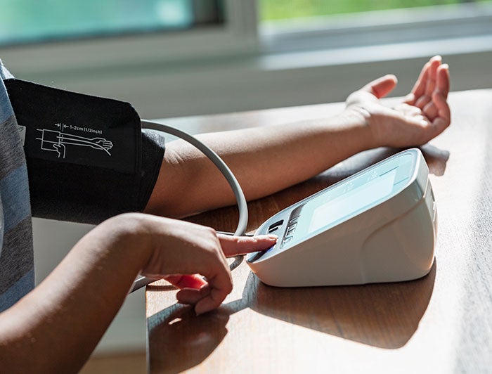 UCF Healthcare. A person's arm, wrapped in a blood pressure cuff, is outstretched on a table