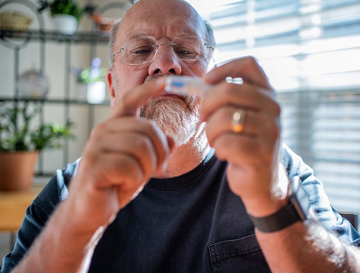 Hartford HealthCare. A man pricks his finger for a glucose test