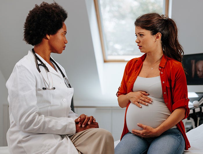 Louisiana Children’s Medical Center. A pregant woman sits talking with a female physician