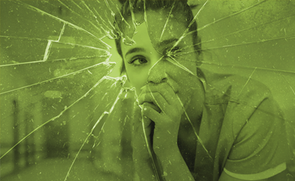 Advancing Hospital Safety and Team Resilience. A hospital clinician in scrubs looks through the whole at the center of a shattered window.