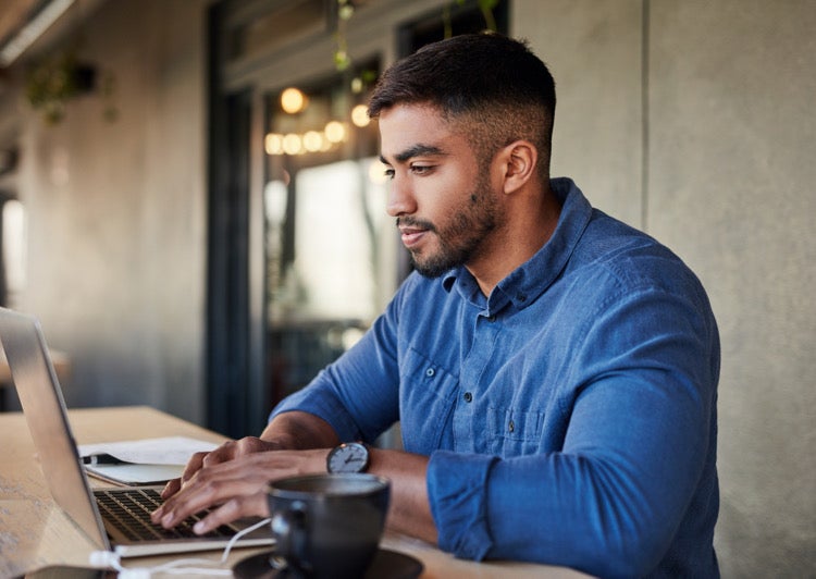 Male at a computer with coffee