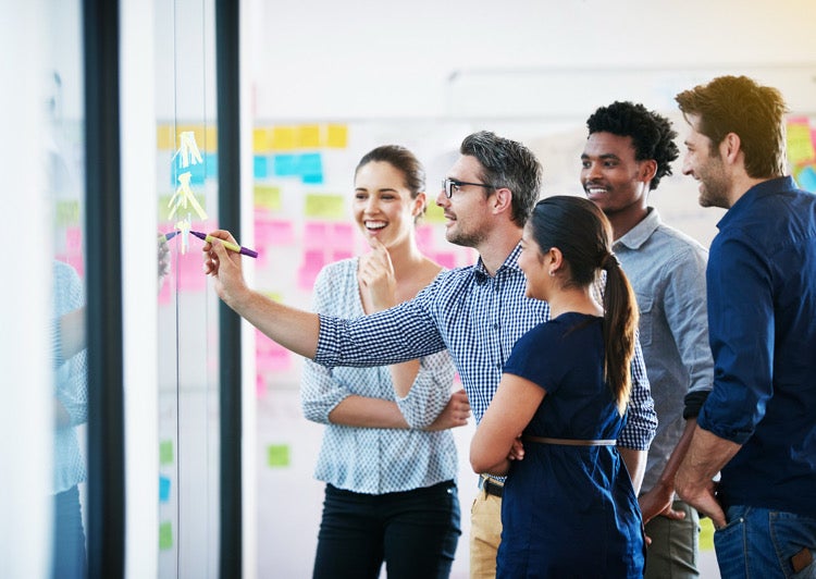 Young people discussing around a whiteboard