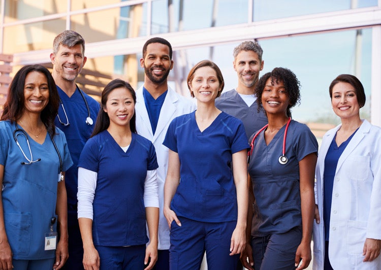 Multiple medical staff standing together for an image all smiling