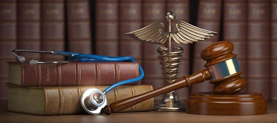 Release 2025.11 Add Image Test. A stethoscope, a gavel, a Caduceus, and legal books on a table in front of a legal library.