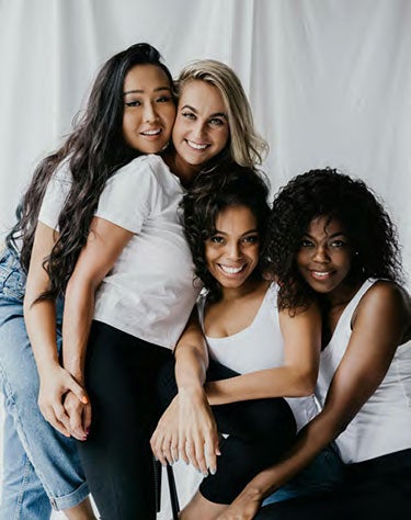A group of four females together with smiles