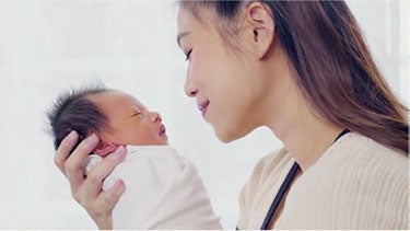 Mother holding newborn baby wrapped in cloth