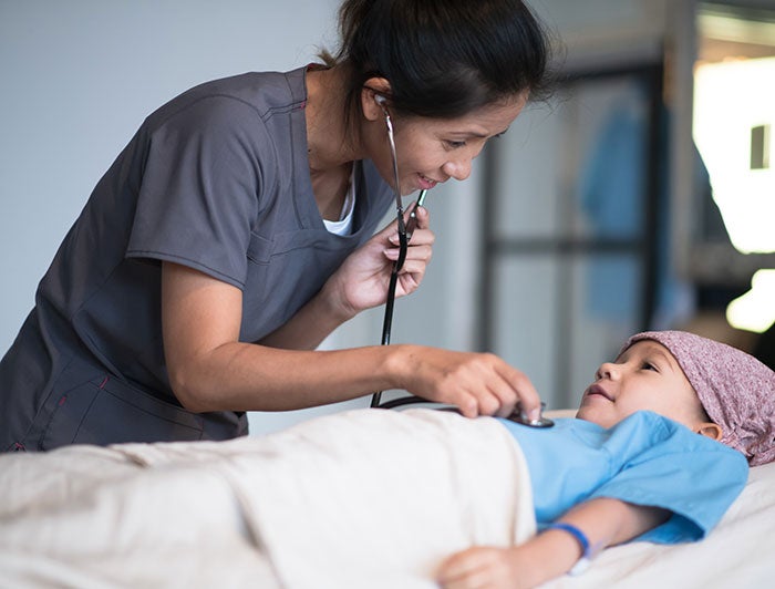 Telling the Hospital Story: Healing comes full circle at Loma Linda University Children’s Health; A female physician checks listens to a pediatric cancer patients heart with a stethoscope